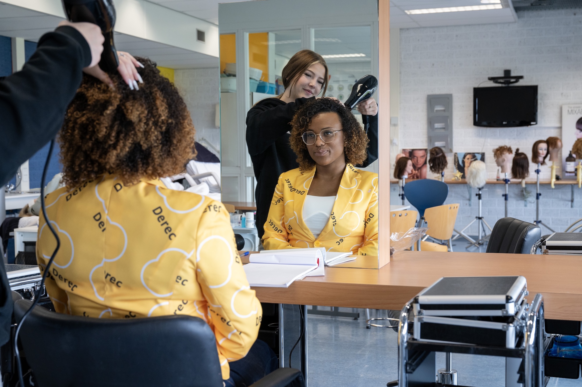 mbo-student doet de haren van de mbo-docent op een kappersopleiding